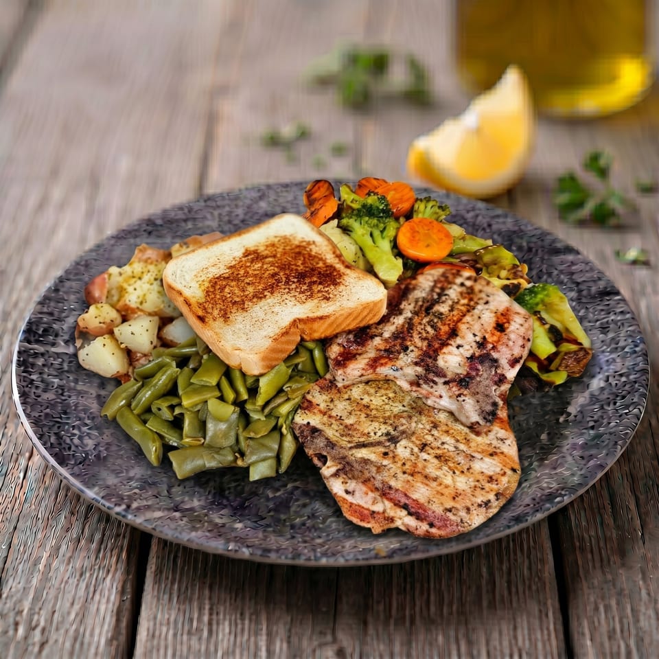 Grilled chicken, green beans, roasted potatoes, and mixed vegetables with toast on a plate.